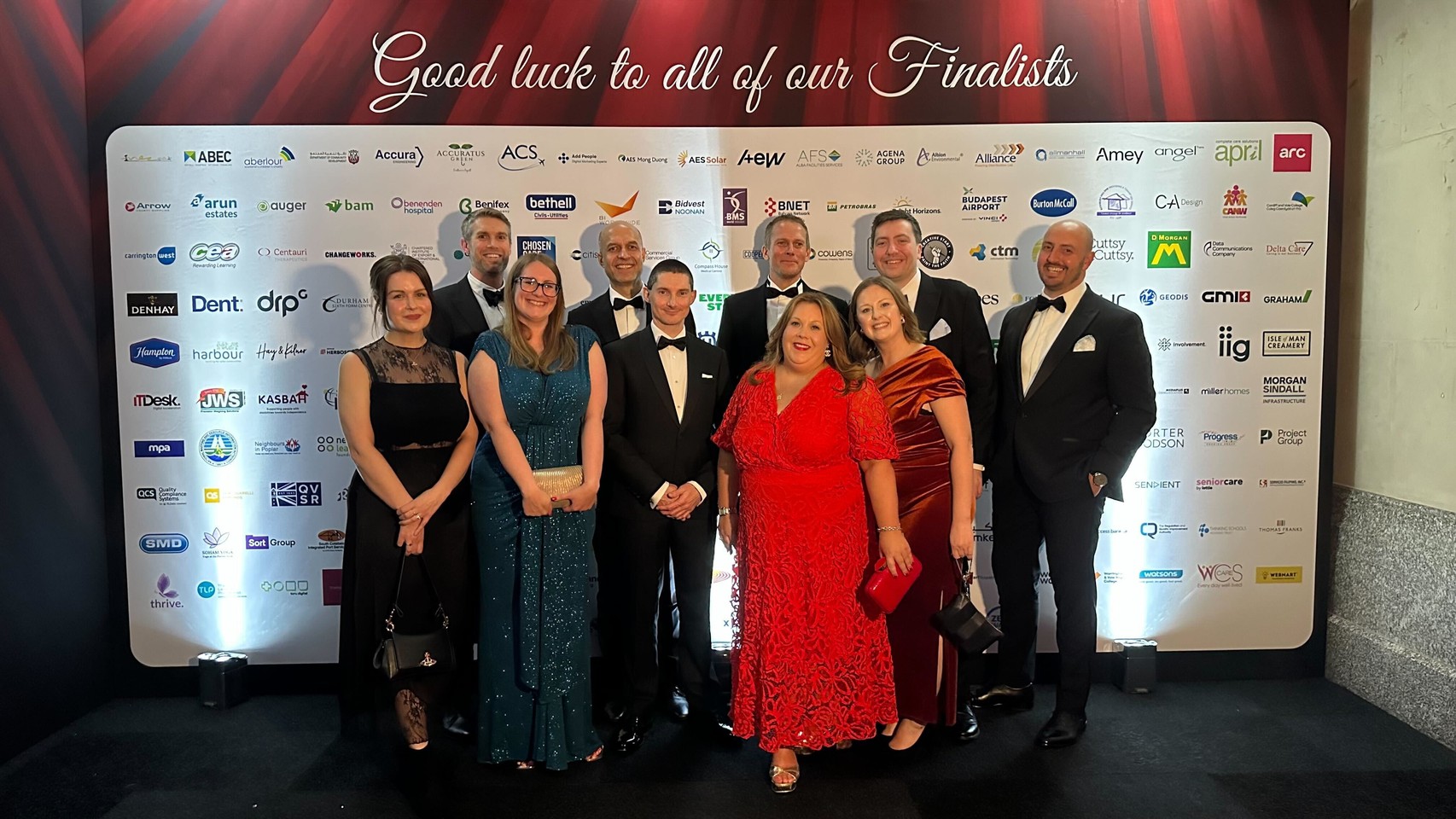 Members of the Fivium team at the IIP awards, in front of a wall of nominee logos
